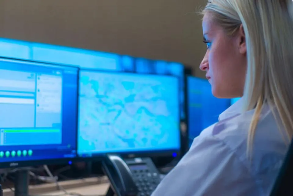 Junge Frau schaut auf Monitore
